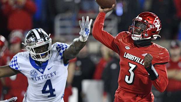 Nov 27, 2021; Louisville, Kentucky, USA; Louisville Cardinals quarterback Malik Cunningham (3) throws a pass against Kentucky Wildcats defensive end Josh Paschal (4) during the second quarter at Cardinal Stadium. Mandatory Credit: Jamie Rhodes-USA TODAY Sports